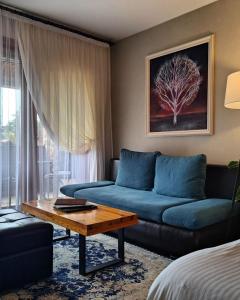 a living room with a blue couch and a table at Aurora Resort & Spa in Berovo