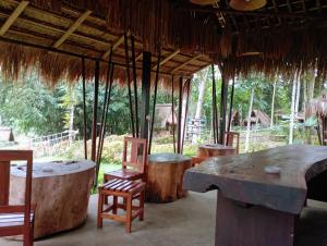 a room with a table and chairs and trees at Sumilir Riverside Retreat in Banyuwangi