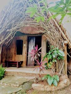 a small house with a thatched roof at Sumilir Riverside Retreat in Banyuwangi