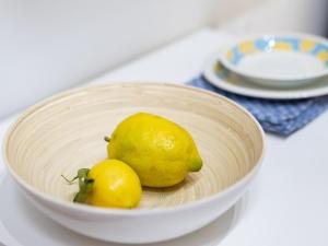 a bowl with two lemons and a pear on a table at Live puertito Fragata With balcony in Puertito de Güímar +29 photos