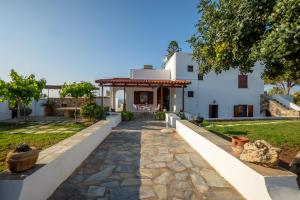 a house with a stone walkway in front of a yard at Villa Ma-Re in Hersonissos