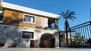 Antalya Silyan Villas في Gedeller: منزل به سور و نخلة