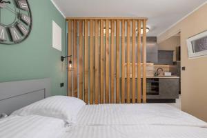1 Schlafzimmer mit einem weißen Bett und einer Küche in der Unterkunft Maisonette Apartment Matej in Lovran