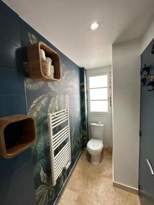 a bathroom with a toilet and a blue wall at Appartement Vieux Mans in Le Mans