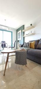 uma sala de estar com um sofá e uma mesa em Oasis en la cala a pasos de mar!! em Cala de Finestrat