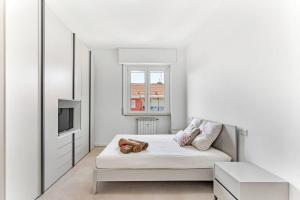 een witte slaapkamer met een bed en een televisie bij Alessia's Flat - Caroli in Milaan