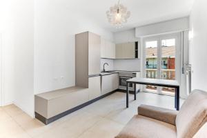 een keuken met witte kasten en een tafel en een bank bij Alessia's Flat - Caroli in Milaan