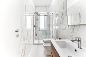 een witte badkamer met een toilet en een wastafel bij Alessia's Flat - Caroli in Milaan +12 foto's