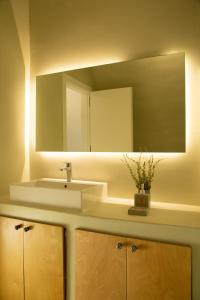 een badkamer met een wastafel en een spiegel bij Amphora Villas Santorini Akrotiri in Akrotiri