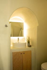 a bathroom with a sink and a mirror at Amphora Villas Santorini Akrotiri in Akrotiri