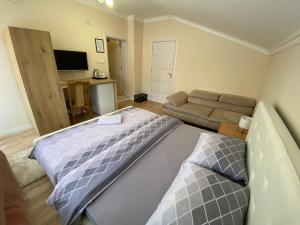 ein Schlafzimmer mit einem großen Bett und einem Sofa in der Unterkunft Apartment Perla in Pristina