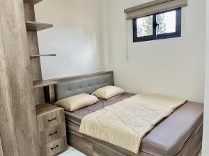een kleine slaapkamer met een bed en een raam bij Sweet Home LGBTQ in Ho Chi Minh-stad