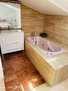 een badkamer met een bad, een wastafel en een bad bij Espectacular Atico vista al mar y montaña in Sant Andreu de Llavaneres