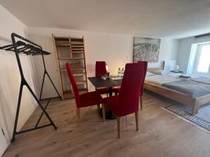 um quarto com uma cama, uma mesa e cadeiras em Appartement en vieille ville de Porrentruy em Porrentruy