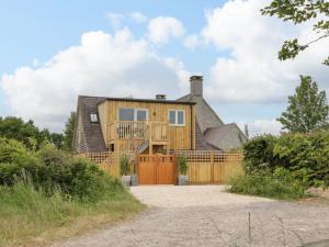 a house with a wooden fence in front of it at The Attic at Redmond Bottom in Wells