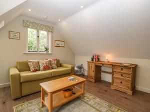 ein Wohnzimmer mit einem Sofa und einem Tisch in der Unterkunft The Attic at Redmond Bottom in Wells