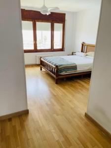 een slaapkamer met een bed en een houten vloer bij Espectacular Atico vista al mar y montaña in Sant Andreu de Llavaneres