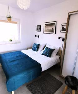 1 dormitorio con 1 cama grande con manta azul en OKej domki Łeba - Nowęcin, en Nowecin