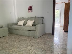 a couch in a living room with a tile floor at Petra Mare Apartments in Alyki
