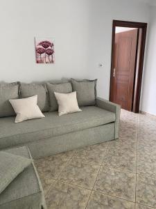 um sofá com duas almofadas numa sala de estar em Petra Mare Apartments em Alyki