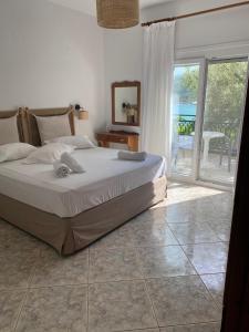 a bedroom with a bed and a large window at Petra Mare Apartments in Alyki