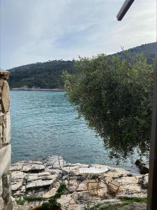a view of a lake with a table and chairs at Petra Mare Apartments in Alyki