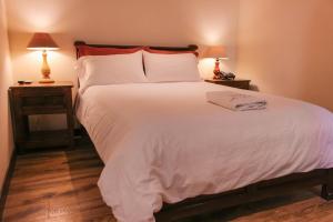 a bedroom with a large white bed with two lamps at Hotel Spa Mansion Santa Isabella in Riobamba