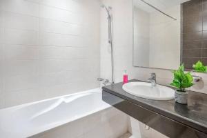 a white bathroom with a sink and a bath tub at BOOK ME! 2 Bedroom Apartment (Sea View) in Abu Dhabi