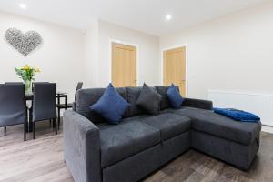 un soggiorno con divano grigio e tavolo di Norris - Parking Wi-Fi Contractors a Preston