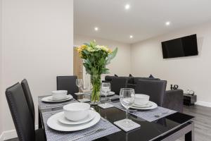 a dining room with a table with a vase of flowers at Norris - Parking Wi-Fi Contractors in Preston