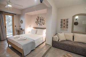 - une chambre avec un lit et un canapé dans l'établissement Pefkon Suites, à Afytos