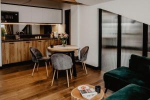 a living room with a table and chairs and a kitchen at Apartamenty Śleboda in Czarny Dunajec