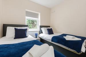 2 letti in una camera con blu e bianco di Norris - Parking Wi-Fi Contractors a Preston