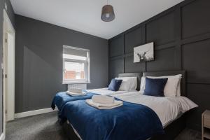 una camera da letto con un grande letto con lenzuola blu di Norris - Parking Wi-Fi Contractors a Preston