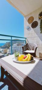 une assiette de fruits sur une table sur un balcon dans l'établissement Oasis en la cala a pasos de mar!!, à La Cala de Finestra