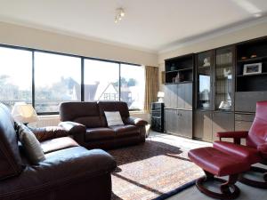 sala de estar con sofá y silla en Bries 0202 apartment with a sunny terrace, en De Haan