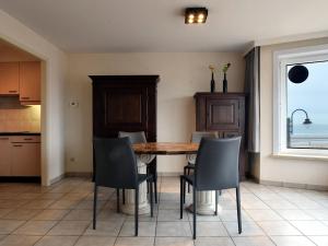 eine Küche mit einem Tisch und Stühlen sowie einem Fenster in der Unterkunft Celine 0201 apartment in De Haan in De Haan