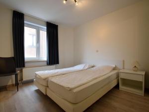 ein weißes Schlafzimmer mit einem Bett und einem Fenster in der Unterkunft Celine 0201 apartment in De Haan in De Haan