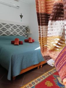 una camera da letto con un letto con cuscini rossi di Riad DAR BARBI a Marrakech