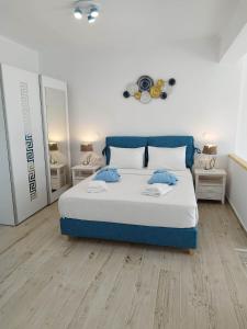a bedroom with a large bed and two tables at ILIOPOULOS Apartments in Mourteri