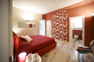 1 dormitorio con cama roja y baño en Villa Pica by PosarelliVillas, en San Corrado di Fuori