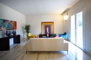 sala de estar con sofá y sillas en Villa Pica by PosarelliVillas, en San Corrado di Fuori