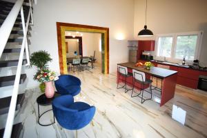 cocina y sala de estar con sillas azules y barra. en Villa Pica by PosarelliVillas, en San Corrado di Fuori
