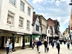 a group of people walking down a street with buildings at Charming 4-Bed House in Winchester Free Parking in Winchester