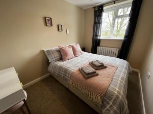 a bedroom with a bed with two towels on it at Charming 4-Bed House in Winchester Free Parking in Winchester