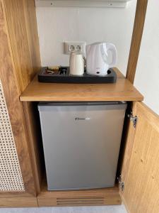 a small refrigerator with a coffee maker on top of it at Pelagos Studios in Platis Gialos