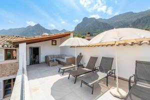 a patio with chairs and an umbrella on a house at S'alqueria in Sóller