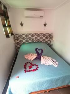 Una cama con dos pares de guantes y flores. en Riad DAR BARBI, en Marrakech