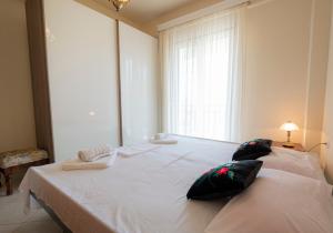 a large white bed in a room with a window at Anastasia Sea View by RentalsPro Services - Nea Potidaia Halkidki in Nea Potidaea