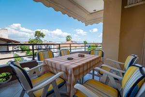 a patio with a table and chairs on a balcony at Anastasia Sea View by RentalsPro Services - Nea Potidaia Halkidki in Nea Potidaea